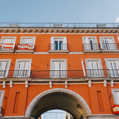 An orange building with an arched doorway and lots of white-trimmed windows